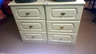 A pair of white bedside cabinets