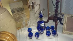 A claret jug with 6 glasses & a blue decanter with 7 glasses