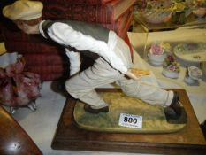 A figure of a man bowling