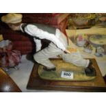 A figure of a man bowling