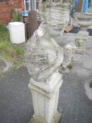 A concrete garden ornament on plinth