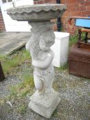 A concrete figure birdbath