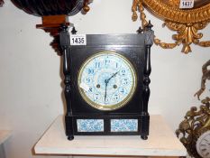 An ebonised mahogany mantel clock with blue and white porcelain face,