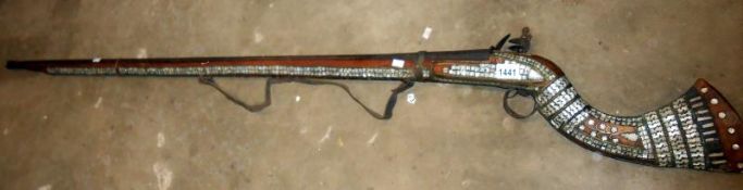 An old Turkish flintlovk rifle with mother of pearl inlay,