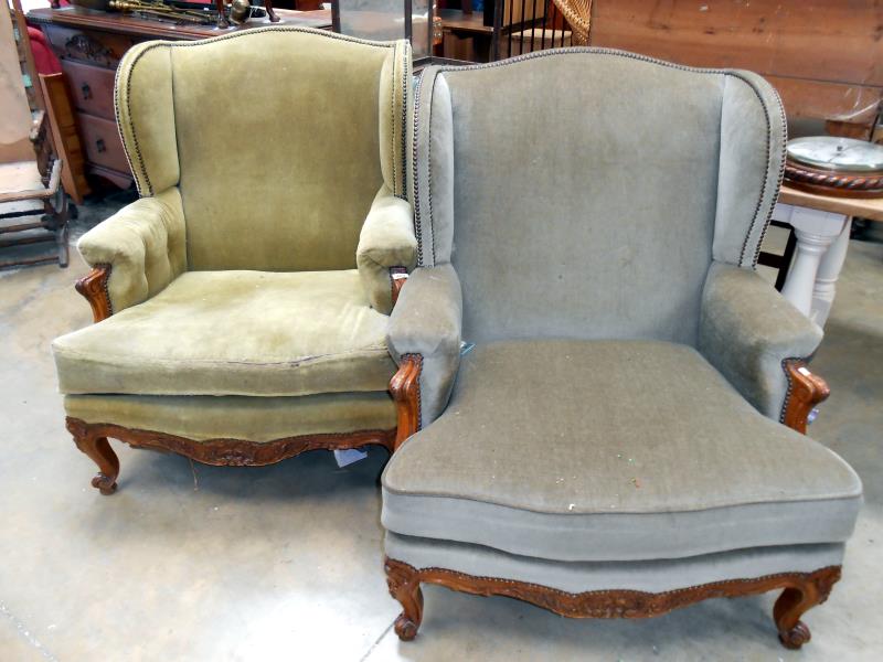 A pair of old wing armchairs with carved wood 'frieze' on scroll feet