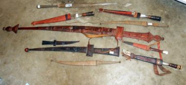 8 African daggers in sheaths and 1 other and a spear head,