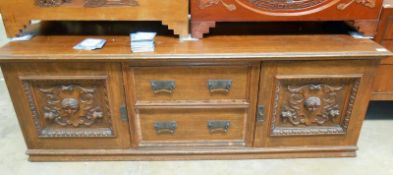 A 19th century low dresser base with heavily carved doors