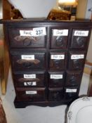 A wooden spice / collectors draw cabinet with metal fittings