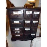 A wooden spice / collectors draw cabinet with metal fittings