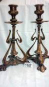 A pair of ornate copper candle sticks