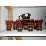 Coloured glass jug and 6 glasses with gold coloured lining