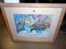 A watercolour of flowers in baskets signed M Barton