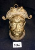 An early 20th century cast bronze African mask of a male head with headdress.