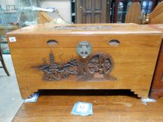A good early 20th C Camphor wood trunk with heavy carved ornamental scenes