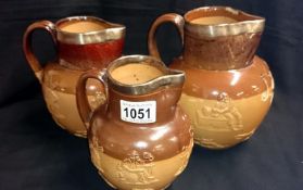 3 graduated Doulton Lambeth stoneware jugs with silver rims A/F