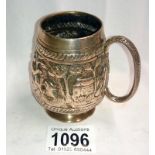 An antique white metal tankard decorated with a lion,