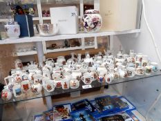 84 items of crested china ware from various makers including loving cups, ewers,