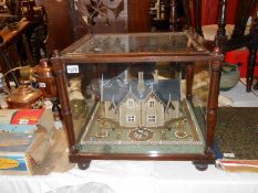 A very unusual table display of a house and gardens in glass display case