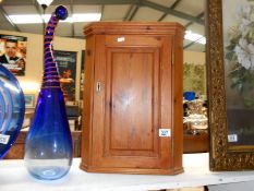 A small pine bathroom corner cupboard