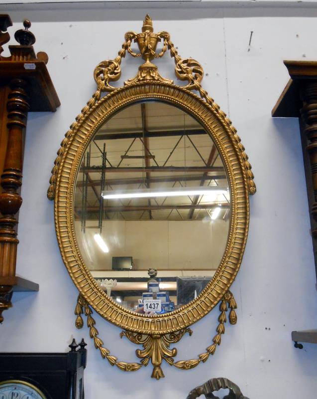 An ornate gilt framed oval mirror