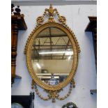 An ornate gilt framed oval mirror