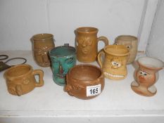 A collection of 8 pottery ugly mugs and vases