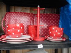 A collection of white polka dot on red crockery etc.