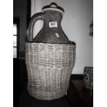 A stoneware flagon in a wicker basket