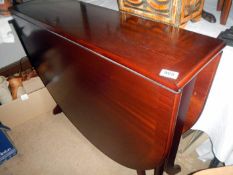 A mahogany effect dark stained drop leaf table