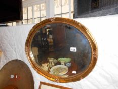 An oval bevelled gilded mirror