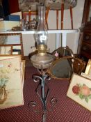 An adjustable wrought iron and copper oil lamp