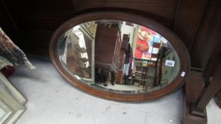 A bevel edged wall mirror in oak frame