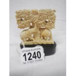 An antique ivory carving of elephants under a tree