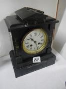 A black slate mantel clock with key and pendulum