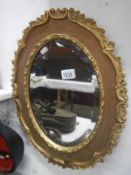 An attractive oval gilt mirror