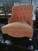 An Edwardian peach covered nursing chair with buttoned back and Queen Anne legs