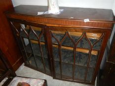 An Edwardian display cabinet with astragal glazed doors & fabric covered shelves (missing its legs)