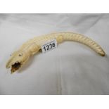 An unusual antique carved ivory crocodile with a man in the back of its mouth