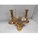 A solid brass dish surmounted by mermaid & a pair of brass candlesticks