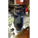 A tall blue glazed stoneware jug featuring dancing peasants marked Guery? Possibly French (height