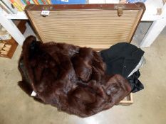 A fur coat & ladies suit jacket with skirt in suitcase