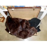 A fur coat & ladies suit jacket with skirt in suitcase