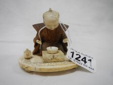 An antique carved ivory and wood figure of a man praying,