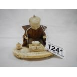An antique carved ivory and wood figure of a man praying,