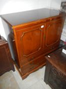 A dark wood stained cupboard with 3 drawers