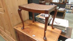 An Edwardian dressing table stool with wicker seat & Queen Anne legs