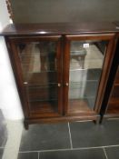 A dark wood stained mahogany effect glazed 2 door display cabinet