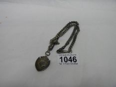 A silver watch chain and a silver fob