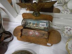 A 1945 souvenir of Germany bottle stand with ship in bottle
