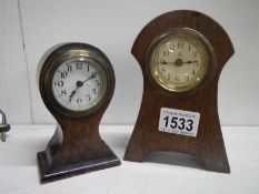 A small mahogany balloon clock and an arts and crafts clock